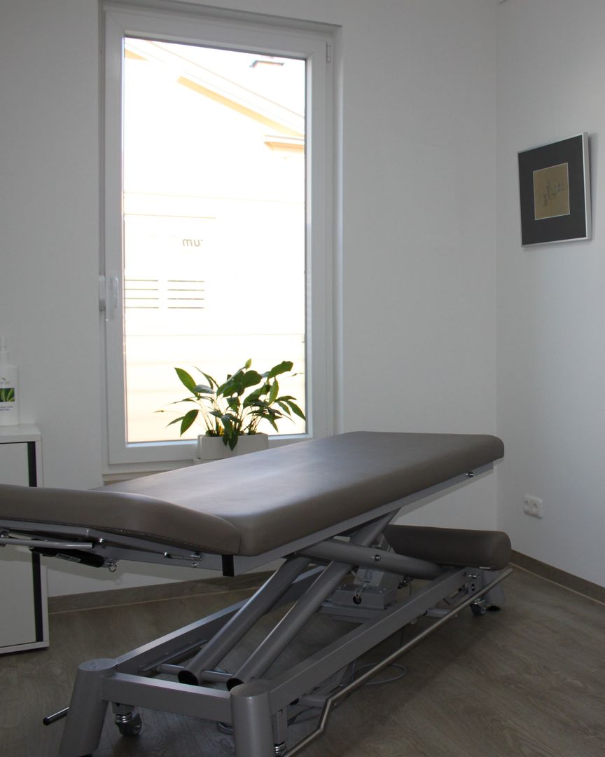 Behandlungsraum mit Therapieliege am Fenster