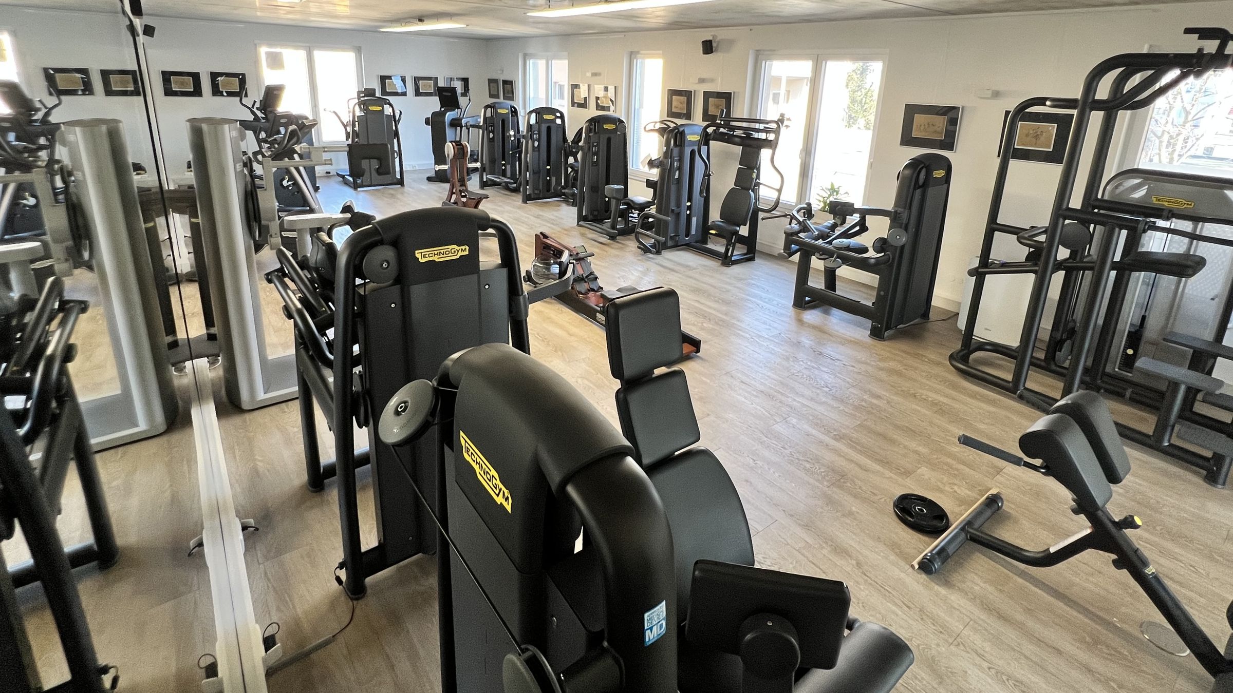 Trainingsfläche des Therapiezentrums mit Technogym-Geräten vor großen Fenstern